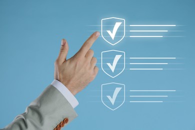 Image of Approved. Man touching check mark on virtual screen against pastel blue background, closeup