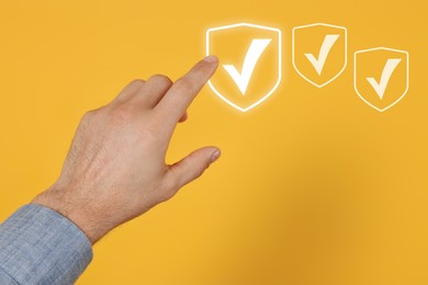 Image of Approved. Man touching check mark on virtual screen against orange background, closeup