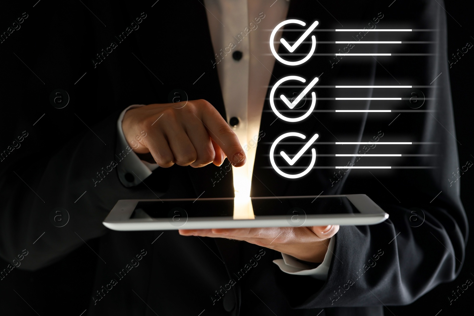 Approved. Man using tablet on black background, closeup. Check marks above device Image of Approved. Man using tablet on black background, closeup. Check marks above device