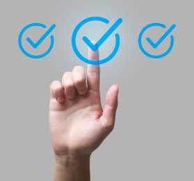 Image of Approved. Man touching check mark on virtual screen against light grey background, closeup