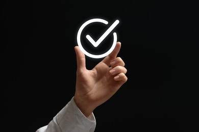 Image of Approved. Woman holding virtual check mark in hand on black background, closeup