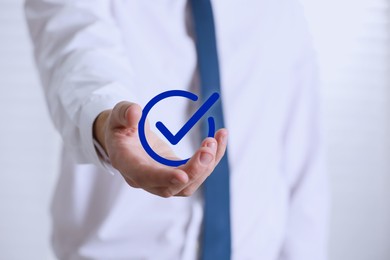 Image of Approved. Man holding virtual check mark in hand on white background, closeup