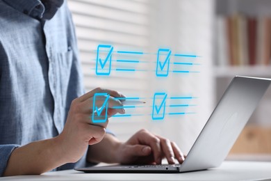 Image of Approved. Man using laptop and touching virtual screen with check marks at table, closeup