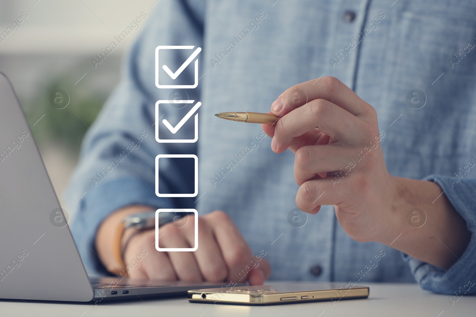 Approved. Man using laptop and checking boxes on virtual screen at table, closeup Image of Approved. Man using laptop and checking boxes on virtual screen at table, closeup