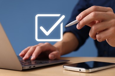Image of Approved. Man using laptop and touching virtual screen with check mark at table, closeup