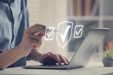 Image of Approved. Man using laptop and touching virtual screen with check marks at table, closeup