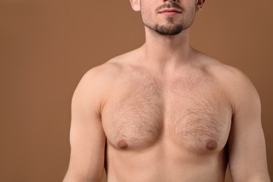 Photo of Young man with hairy chest on brown background, closeup. Epilation procedure