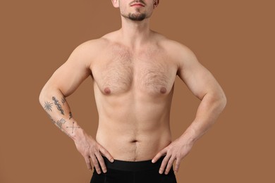 Photo of Young man with hairy chest on brown background, closeup. Epilation procedure