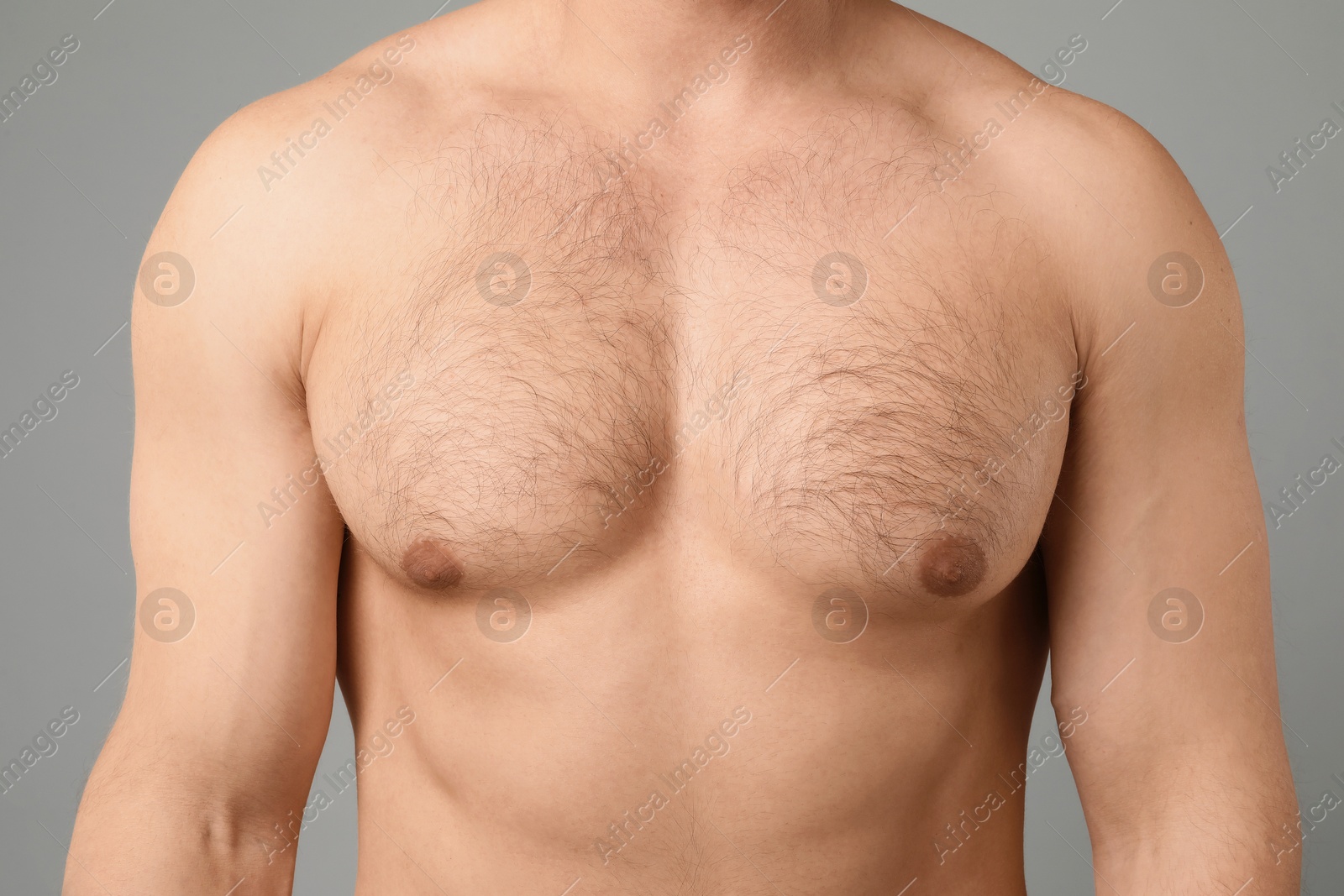 Young man with hairy chest on light grey background, closeup. Epilation procedure Photo of Young man with hairy chest on light grey background, closeup. Epilation procedure