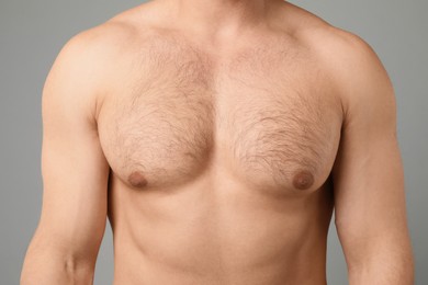Photo of Young man with hairy chest on light grey background, closeup. Epilation procedure