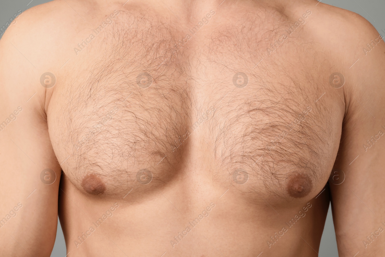 Young man with hairy chest on light grey background, closeup. Epilation procedure Photo of Young man with hairy chest on light grey background, closeup. Epilation procedure