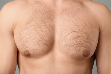Photo of Young man with hairy chest on light grey background, closeup. Epilation procedure
