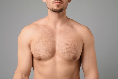 Photo of Young man with hairy chest on light grey background, closeup. Epilation procedure