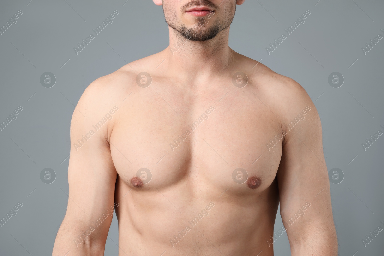 Young man with smooth chest after epilation procedure on light grey background, closeup Photo of Young man with smooth chest after epilation procedure on light grey background, closeup