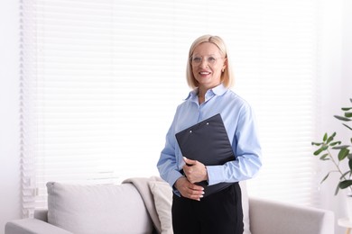 Photo of Professional psychologist with clipboard in office, space for text
