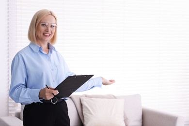 Photo of Professional psychologist with clipboard in office, space for text