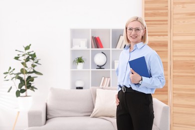 Photo of Professional psychologist with notebook in office, space for text