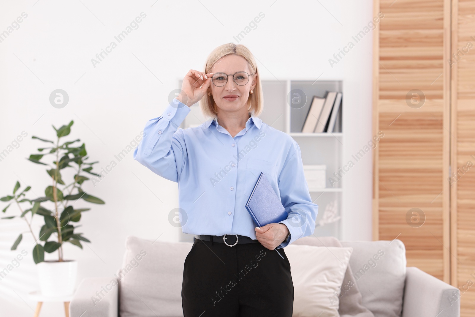 Professional psychologist in glasses with notebook indoors Photo of Professional psychologist in glasses with notebook indoors