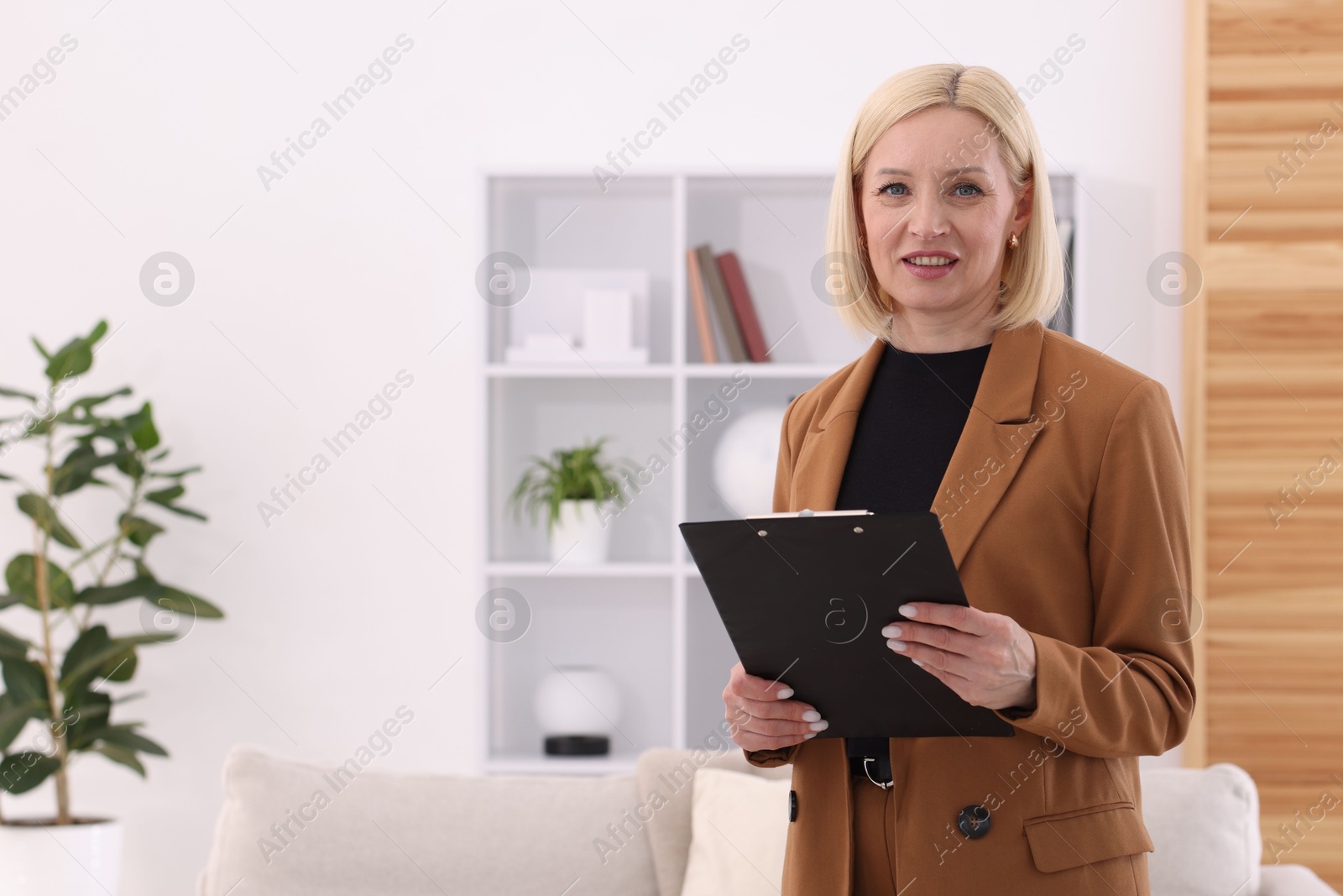 Professional psychologist with clipboard in office, space for text Photo of Professional psychologist with clipboard in office, space for text