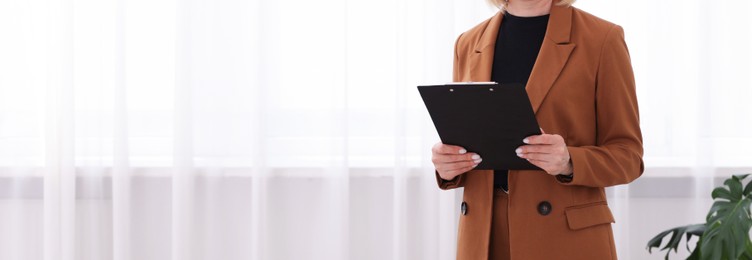 Photo of Professional psychologist with clipboard in office, closeup. Space for text