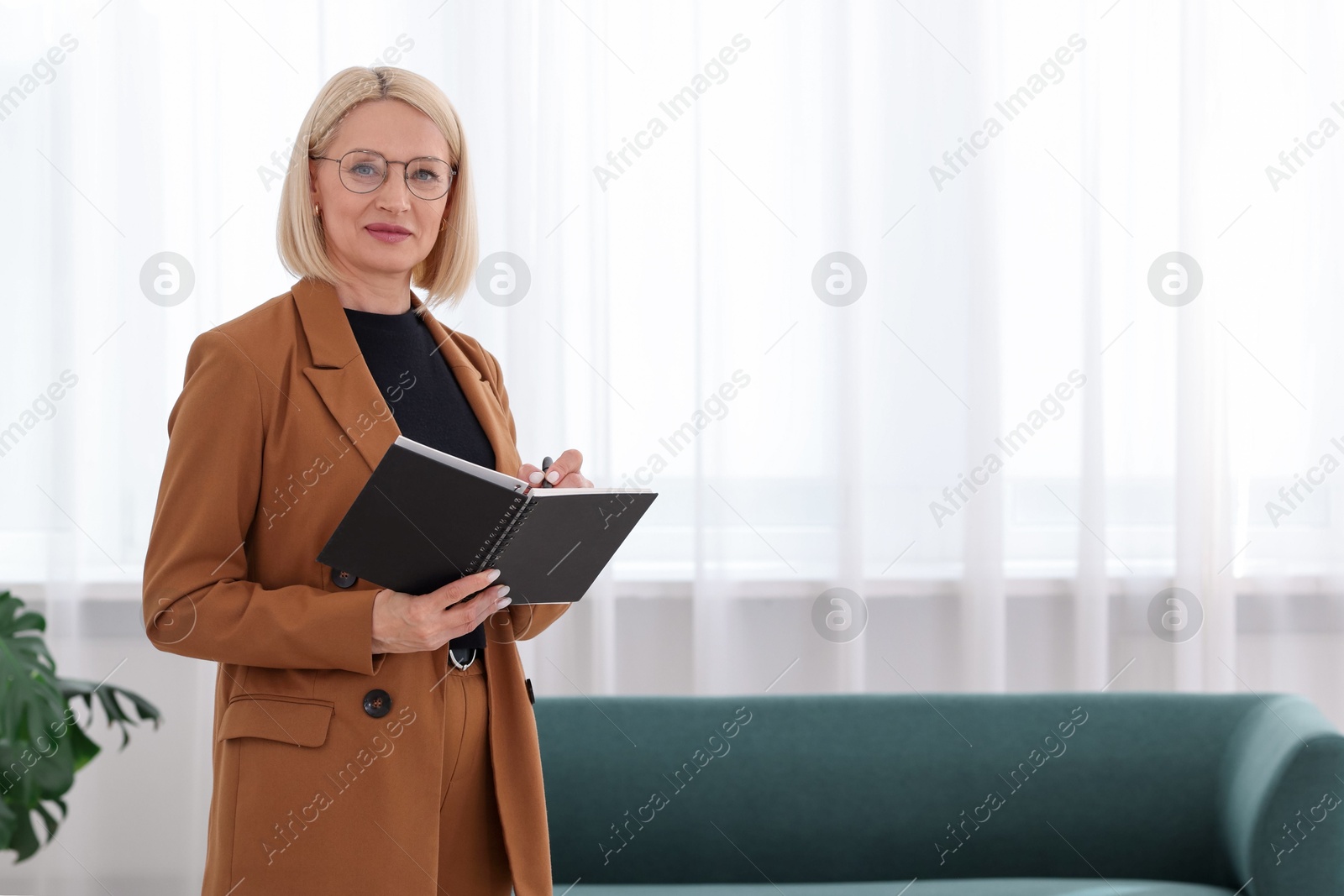 Professional psychologist writing in notebook indoors, space for text Photo of Professional psychologist writing in notebook indoors, space for text