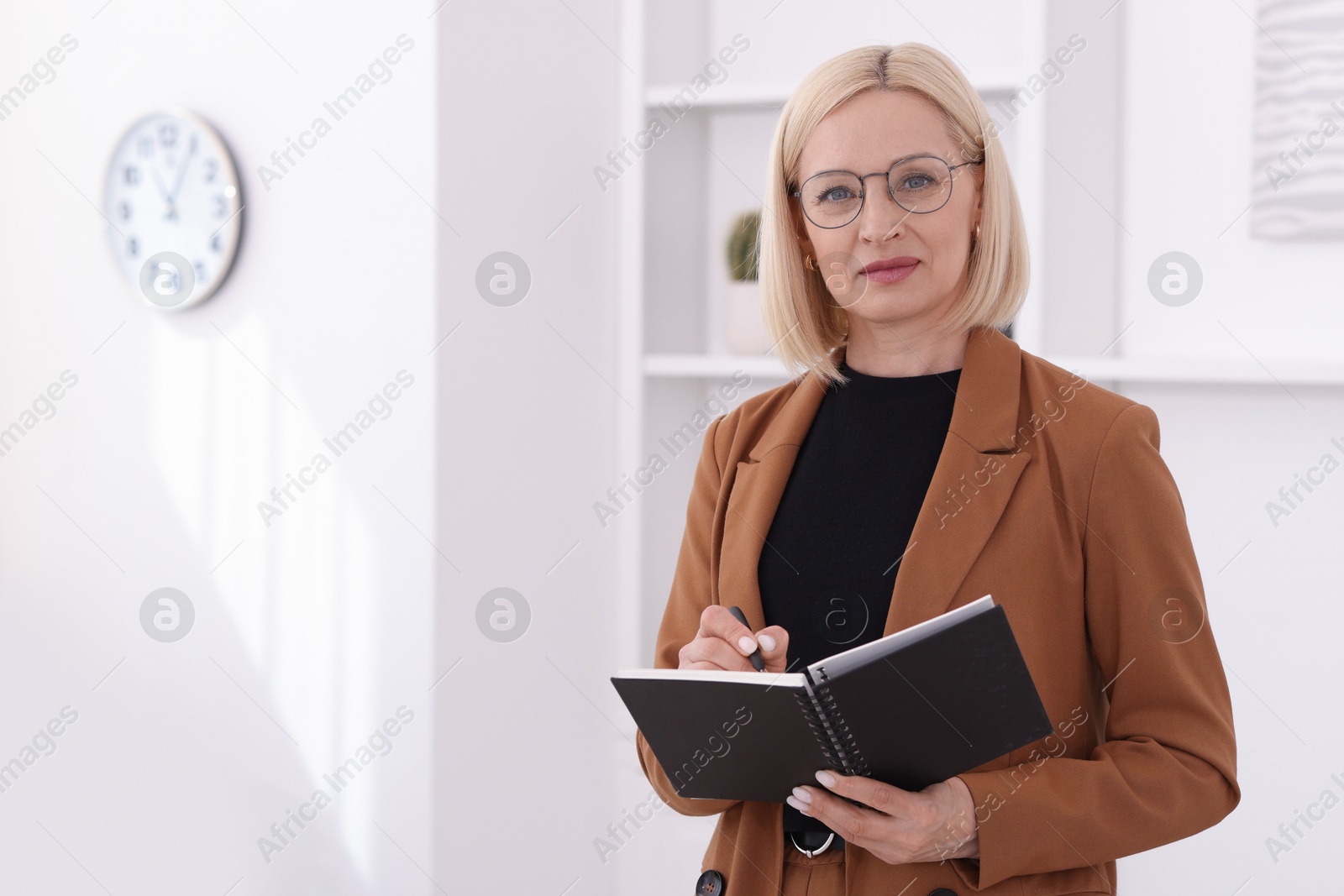 Professional psychologist writing in notebook indoors, space for text Photo of Professional psychologist writing in notebook indoors, space for text