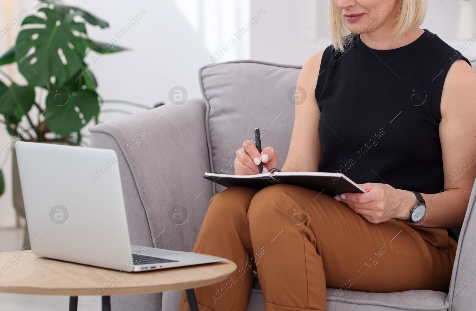 Professional psychologist taking notes while working with laptop in office, closeup Photo of Professional psychologist taking notes while working with laptop in office, closeup