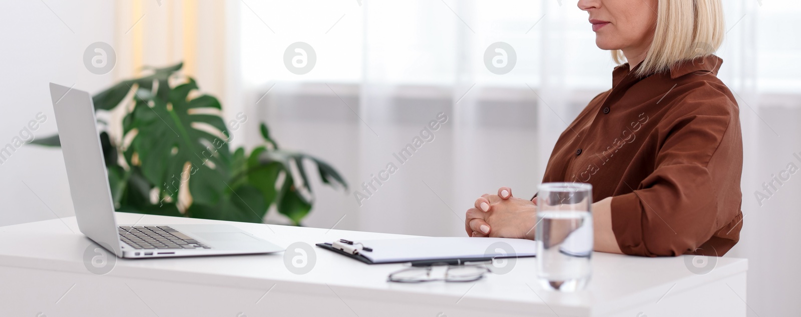 Professional psychologist working with laptop at table in office, closeup Photo of Professional psychologist working with laptop at table in office, closeup