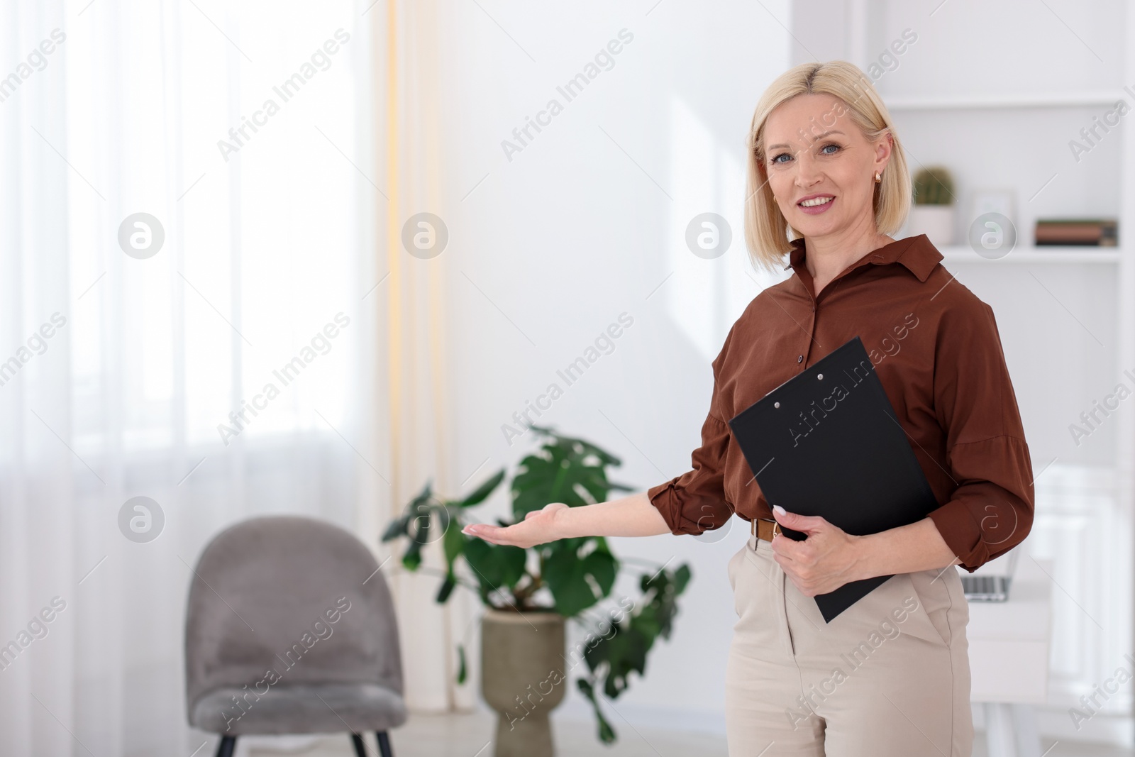 Professional psychologist with clipboard in office, space for text Photo of Professional psychologist with clipboard in office, space for text