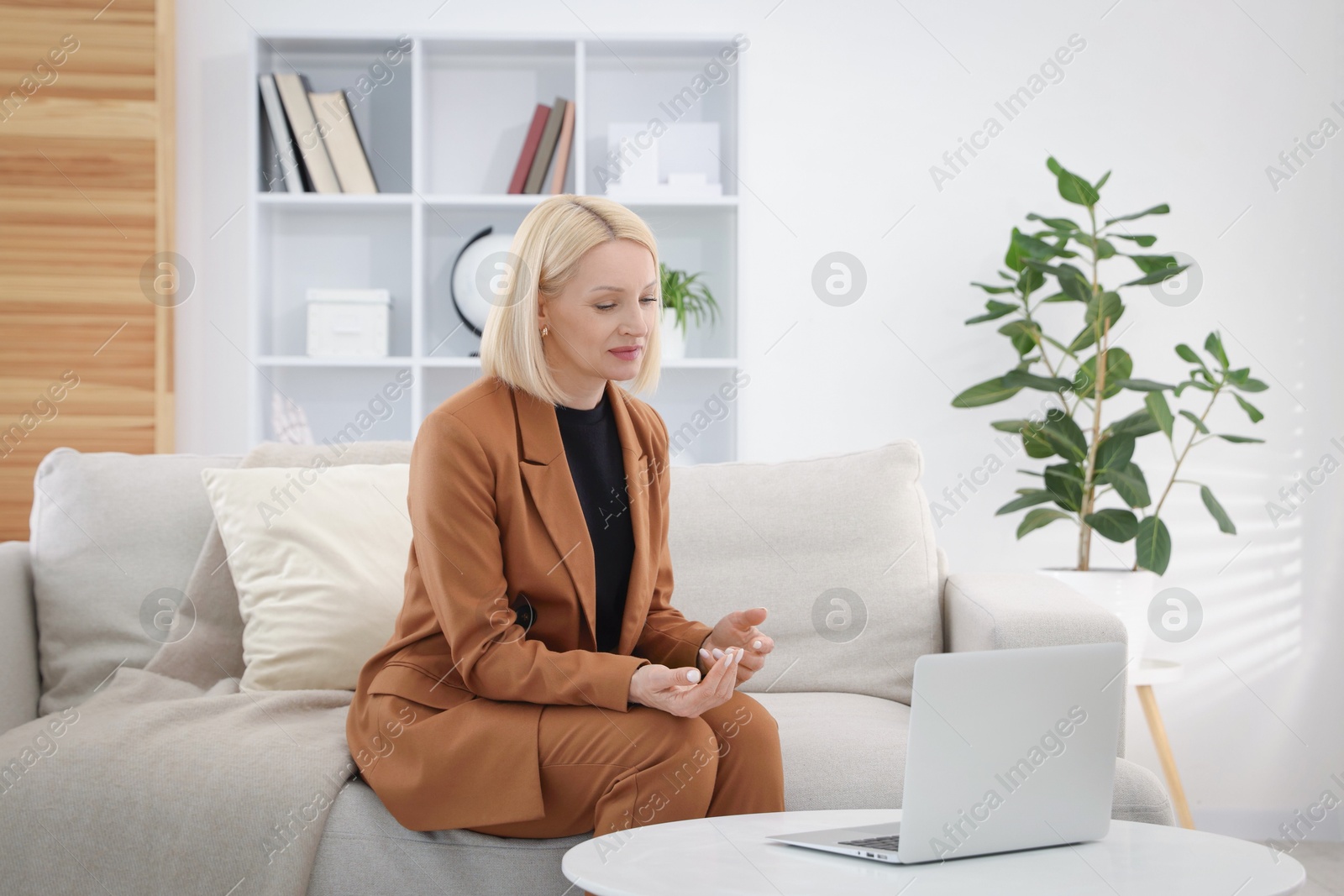 Professional psychologist working with laptop on sofa in office Photo of Professional psychologist working with laptop on sofa in office