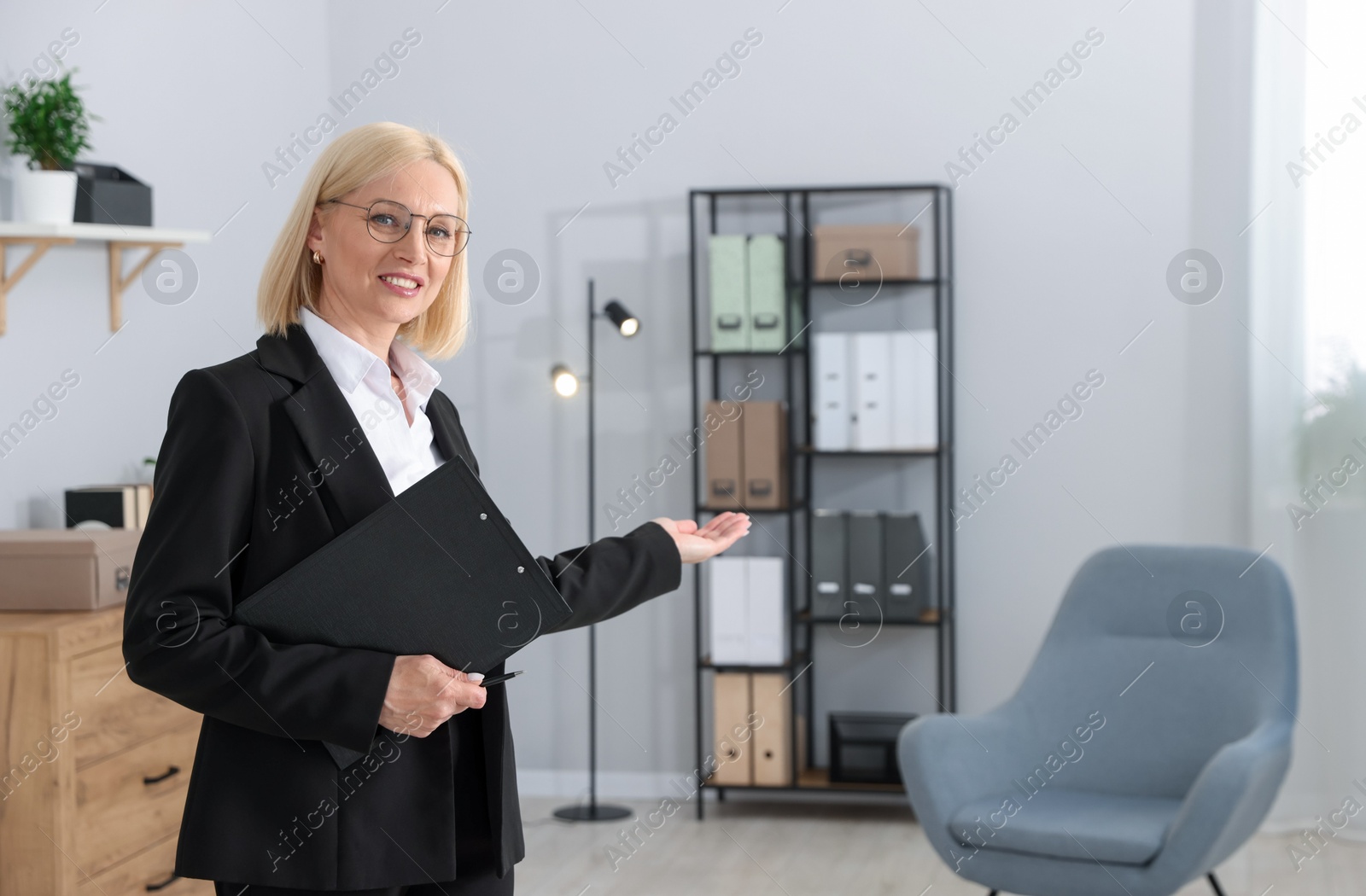 Professional psychologist with clipboard in office, space for text Photo of Professional psychologist with clipboard in office, space for text