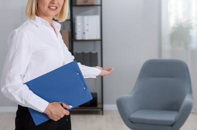 Photo of Professional psychologist with clipboard in office, closeup. Space for text