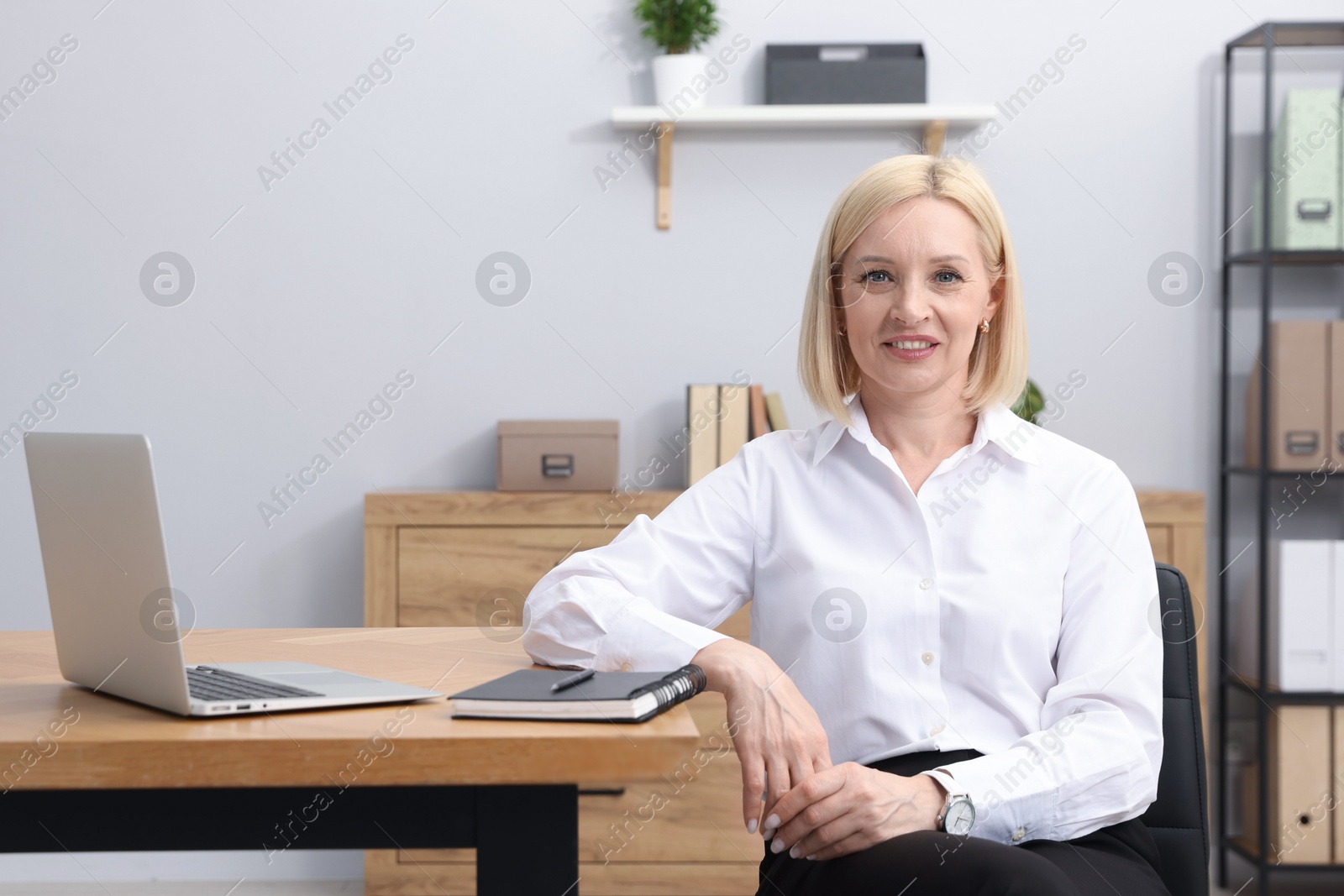 Professional psychologist at table with laptop in office Photo of Professional psychologist at table with laptop in office
