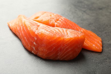 Photo of Seafood. Pieces of salmon fillet on gray table, closeup
