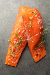 Photo of Seafood. Pieces of salmon fillet with spices on gray textured table, top view