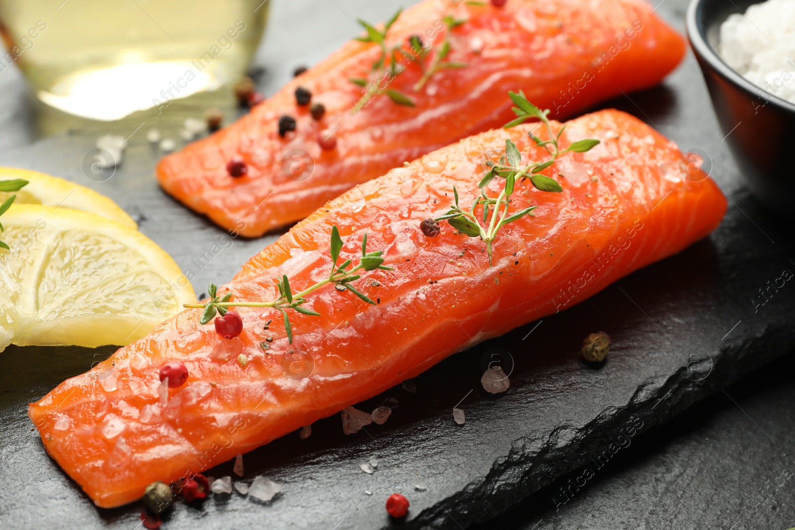 Seafood. Pieces of salmon fillet, spices and lemon on table, closeup Photo of Seafood. Pieces of salmon fillet, spices and lemon on table, closeup
