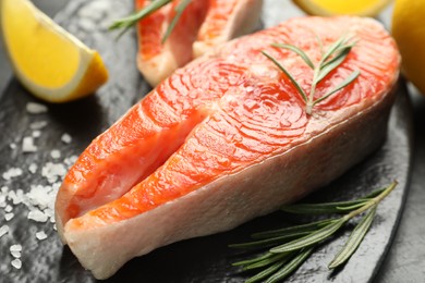 Photo of Seafood. Salmon steaks, rosemary and lemon on table, closeup