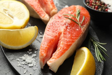 Photo of Seafood. Salmon steaks, spices and lemon on table, closeup