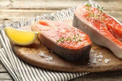 Photo of Seafood. Salmon steaks, spices and lemon wedge on table, closeup