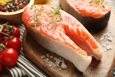 Photo of Seafood. Salmon steaks, spices and tomatoes on table, closeup