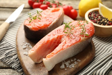 Photo of Seafood. Salmon steaks, spices, tomatoes and lemons on table, closeup