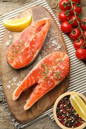 Photo of Seafood. Salmon steaks, spices, tomatoes and lemon wedges on table, flat lay