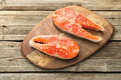 Photo of Seafood. Salmon steaks on wooden table, top view