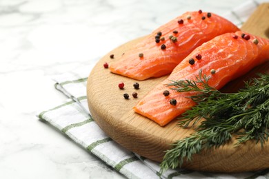 Photo of Seafood. Pieces of salmon fillet and spices on white marble table, closeup