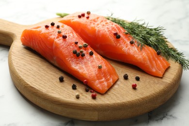 Photo of Seafood. Pieces of salmon fillet and spices on white marble table, closeup