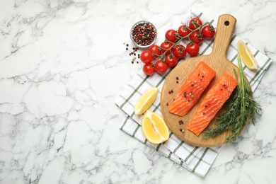 Photo of Seafood. Pieces of salmon fillet, spices, tomatoes and lemon wedges on white marble table, flat lay. Space for text