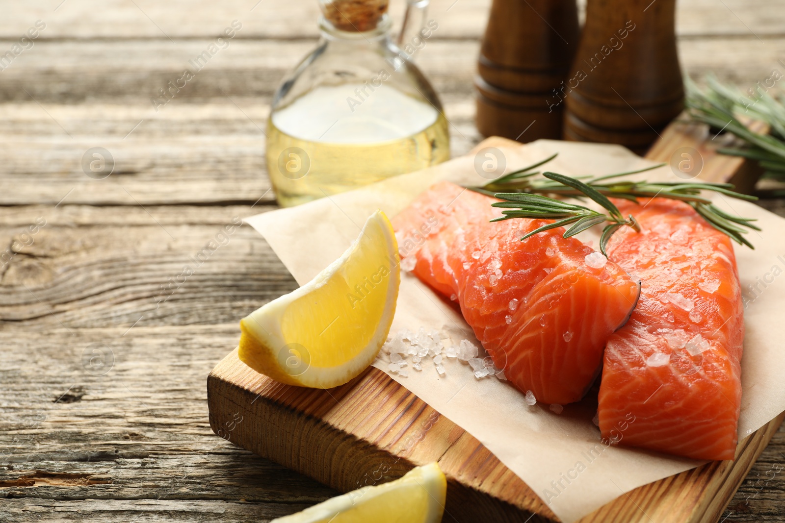 Seafood. Pieces of salmon fillet, spices, oil and lemon wedges on wooden table, closeup Photo of Seafood. Pieces of salmon fillet, spices, oil and lemon wedges on wooden table, closeup