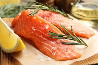 Photo of Seafood. Pieces of salmon fillet, spices, oil and lemon wedge on table, closeup