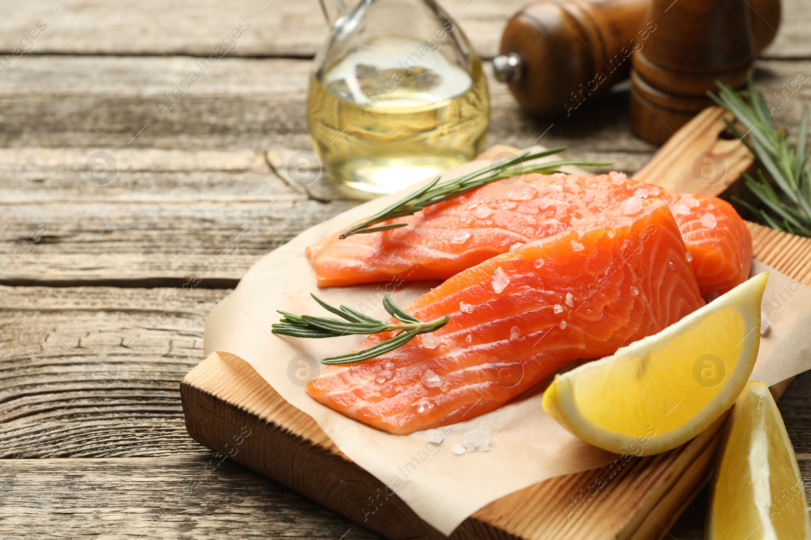Seafood. Pieces of salmon fillet, spices, oil and lemon wedges on wooden table, closeup Photo of Seafood. Pieces of salmon fillet, spices, oil and lemon wedges on wooden table, closeup