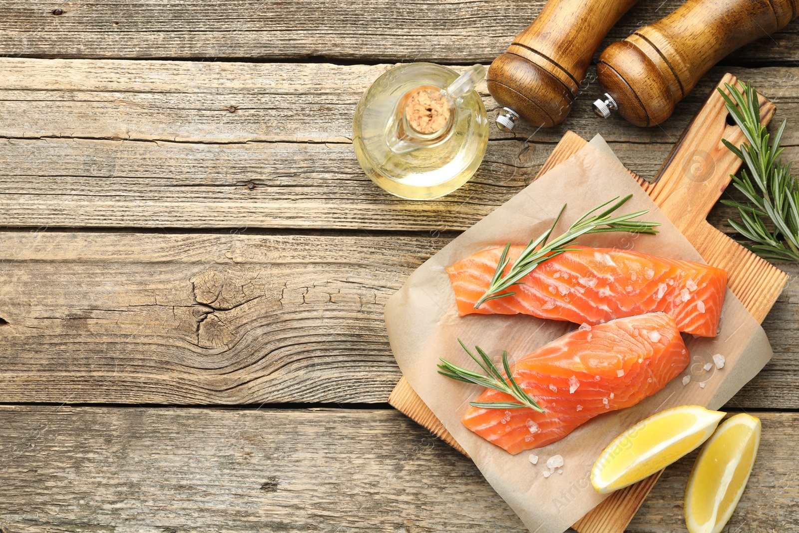 Seafood. Pieces of salmon fillet, spices, oil and lemon wedges on wooden table, flat lay. Space for text Photo of Seafood. Pieces of salmon fillet, spices, oil and lemon wedges on wooden table, flat lay. Space for text